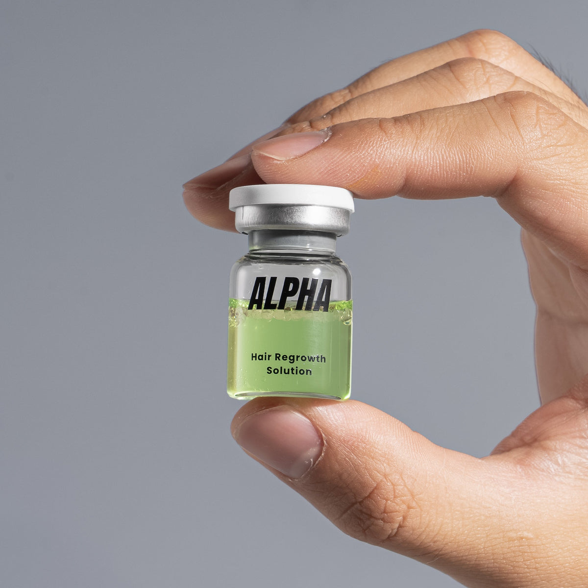 AlphaInfuse Hair Regrowth Serum bottle held in hand